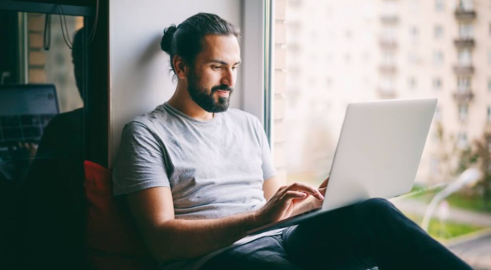 man on computer committing a cyber crime