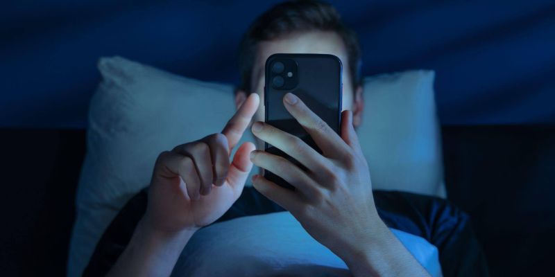 Person in bed using cell phone, reflecting on