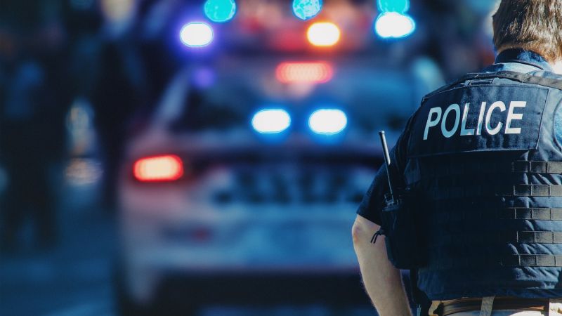 Behind the police with gun belt