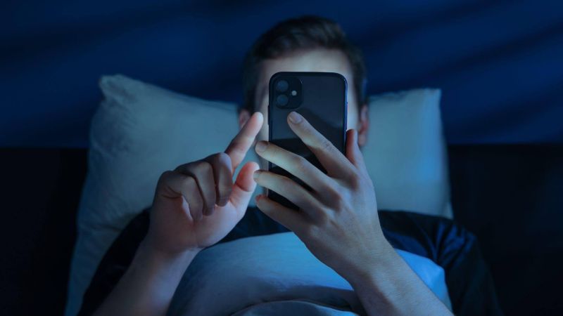 Person in bed using cell phone, reflecting on