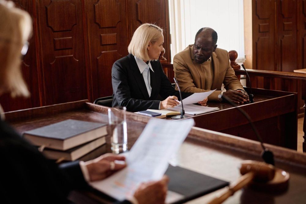 Two people discussing legal defense with an attorney at