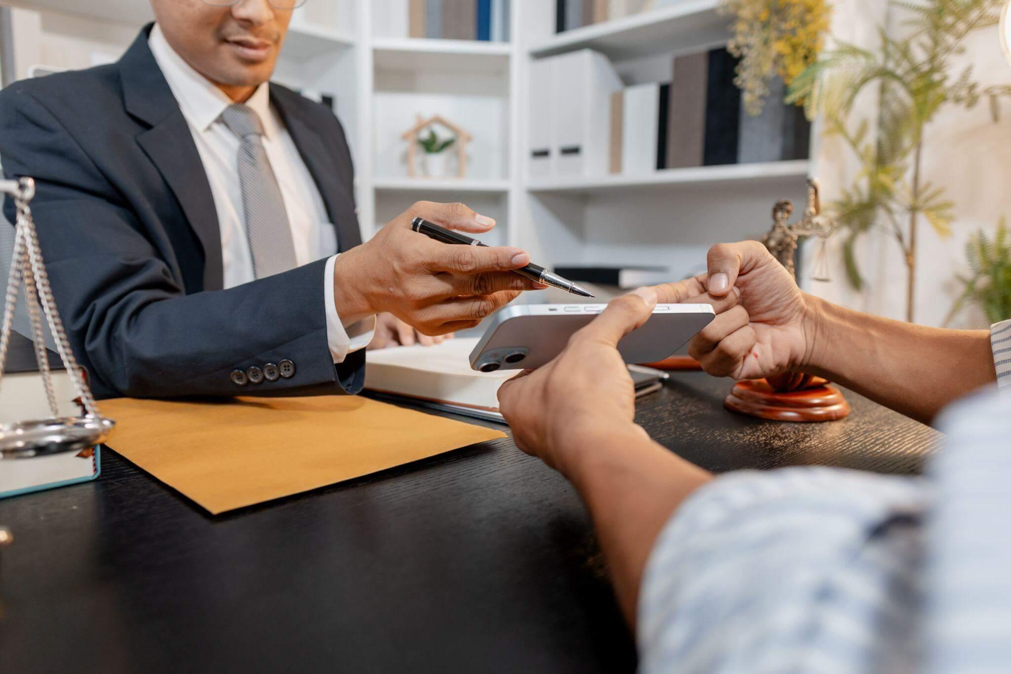 two people sitting at a table with a phone