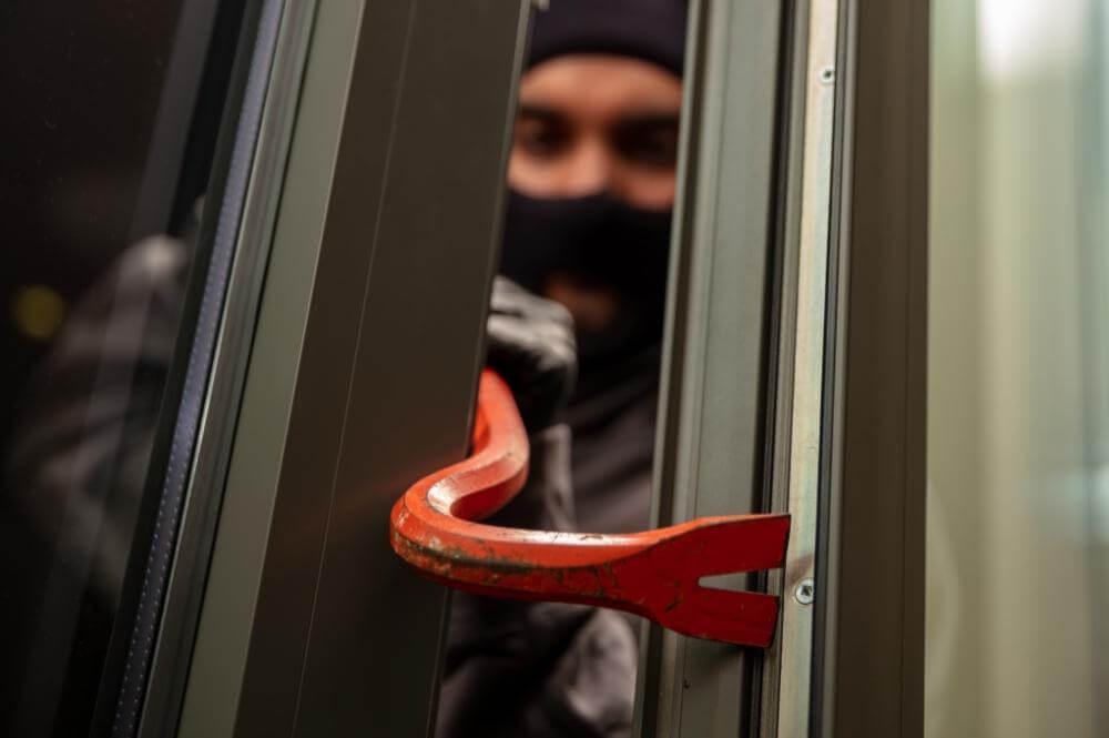 Man in black hoodie holding red handle, representing